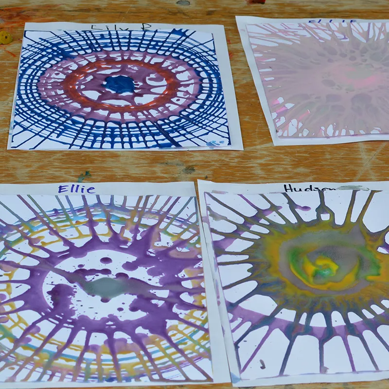 Colorful spin-art painted paper drying on a table